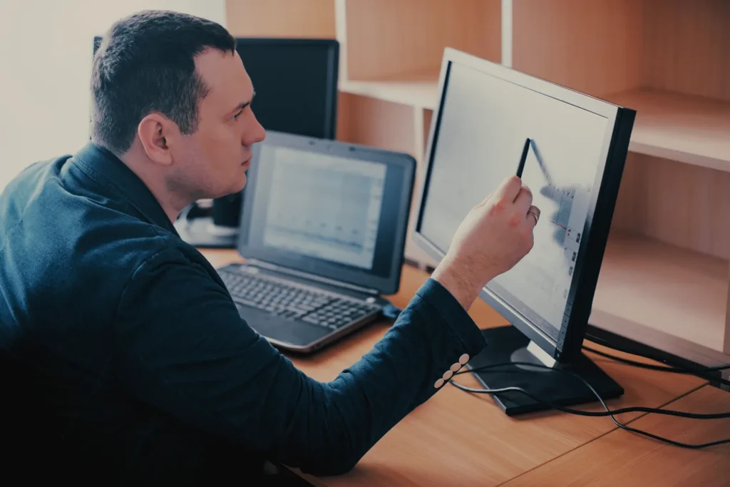 Packaging engineer analyzing data on multiple screens to optimize packaging design